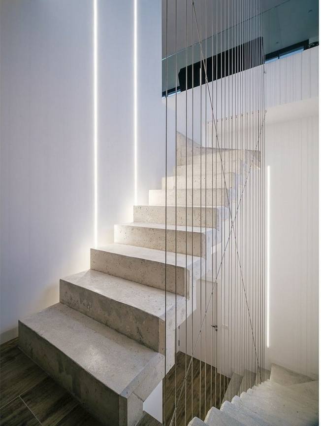 Escalera de peldaños claros con barandilla de cables
