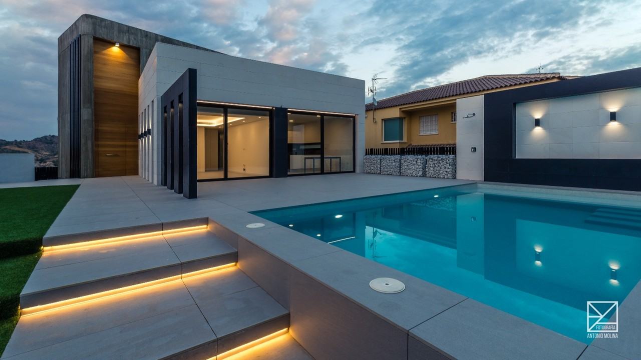 Piscina con escalones iluminados junto a la vivienda